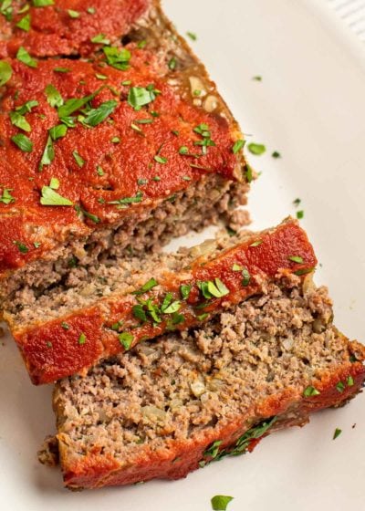 Overhead view of a log of meatloaf with two slices cut from it