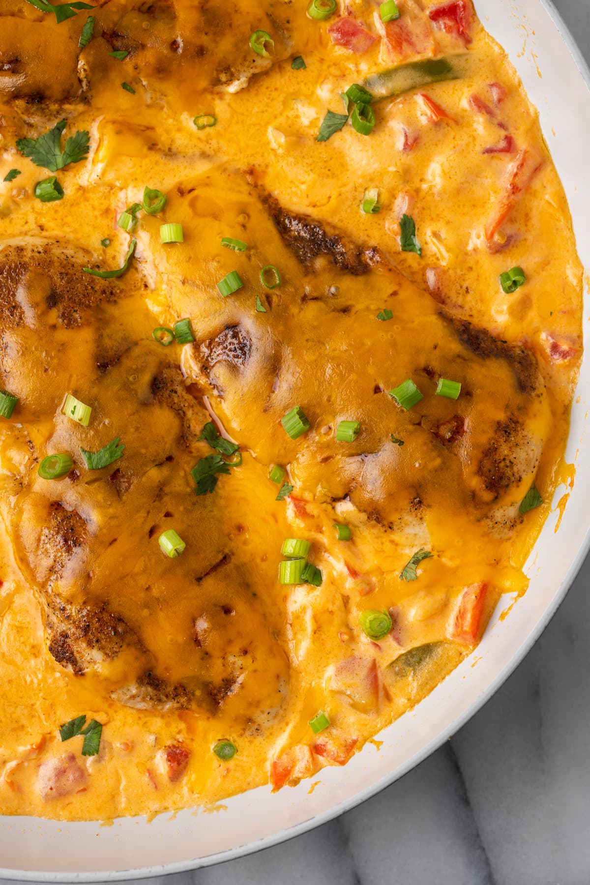 This easy Santa Fe chicken recipe is juicy, tender, rich, and spicy. It only has 6.7 net carbs, and takes just 25 minutes to make. This Santa Fe Chicken is a one-pan recipe packed with your favorite southwestern flavors. Juicy seasoned chicken is paired with peppers, onions, and tomatoes in a creamy, cheesy sauce!