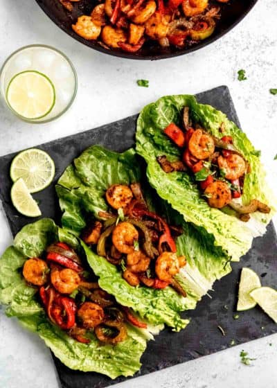 shrimp lettuce wraps being assembled on black cutting board